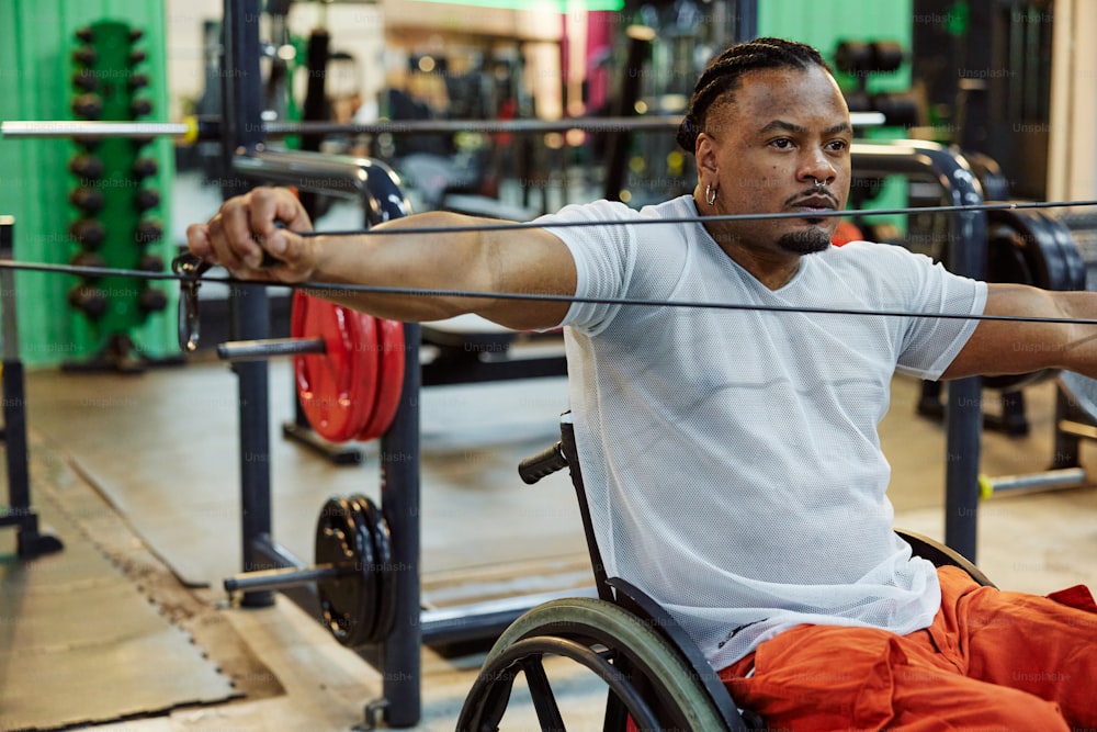 Un hombre en una silla de ruedas sosteniendo una barra