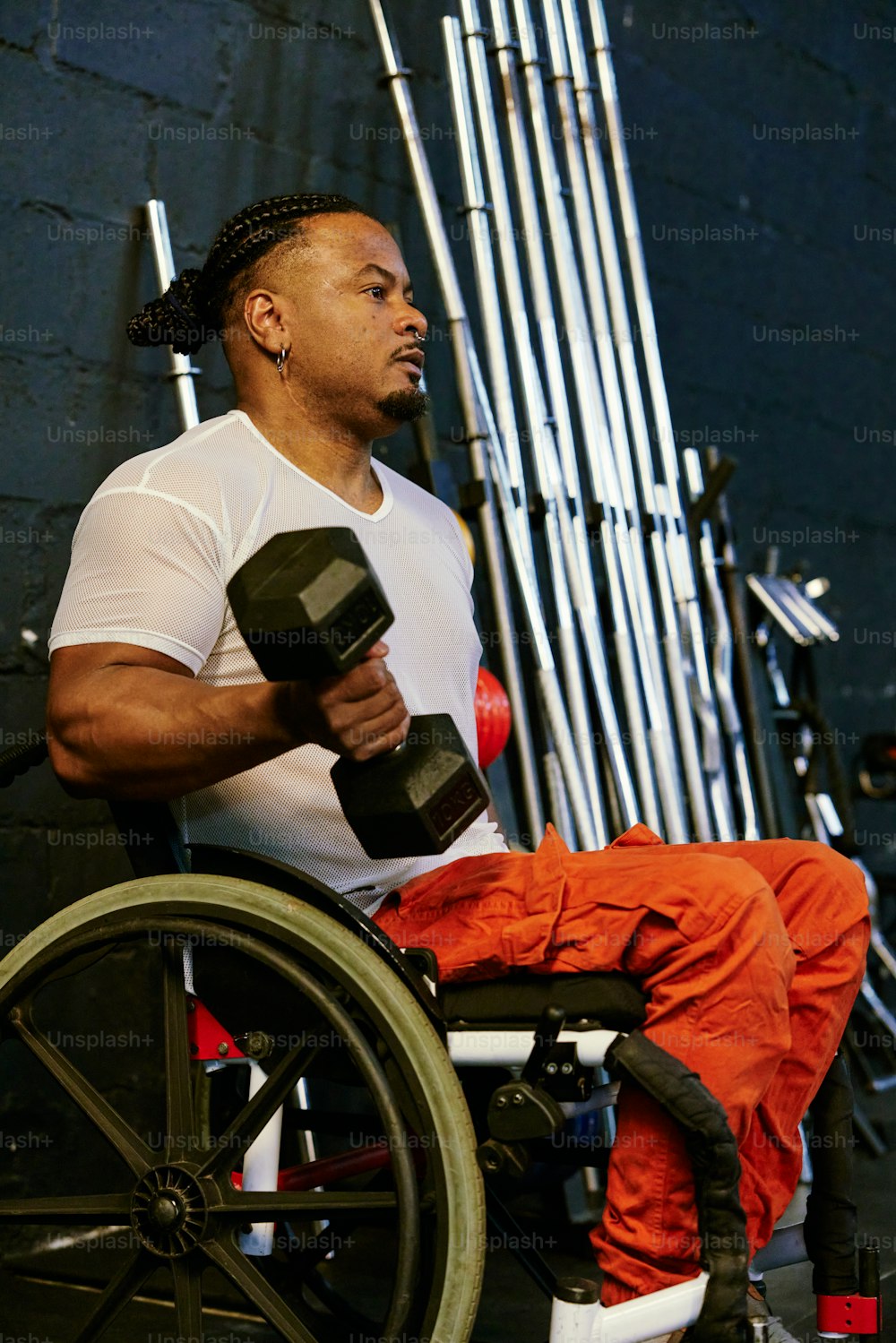 a man sitting in a wheel chair holding a pair of dumbbells