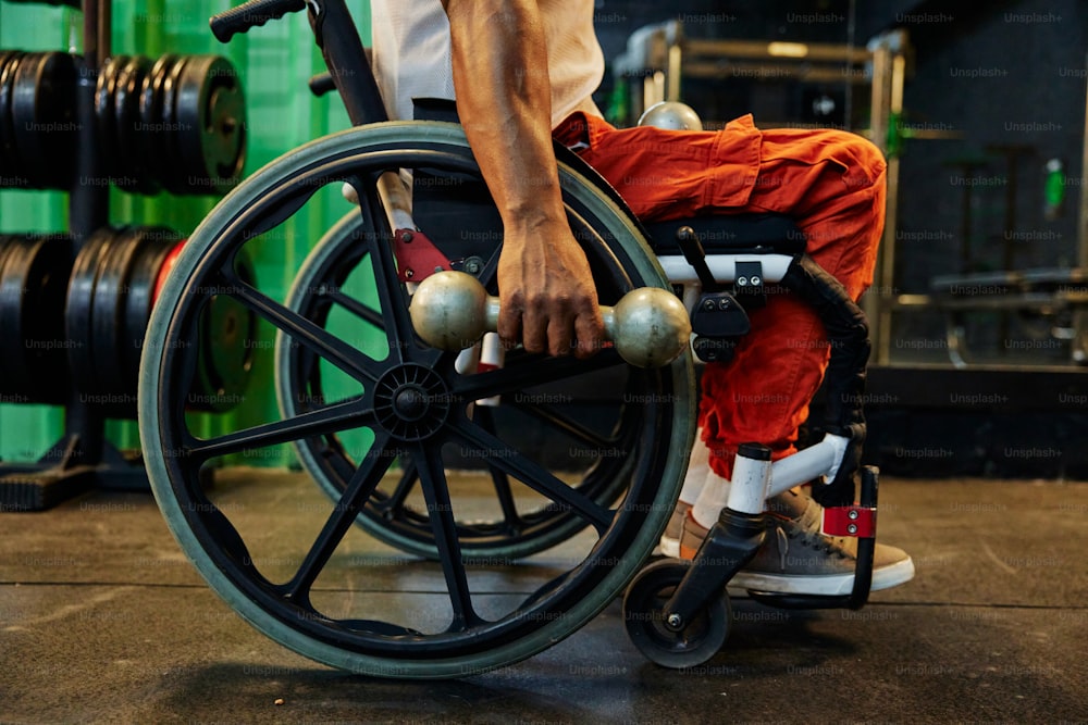 um homem sentado em uma cadeira de rodas em um ginásio