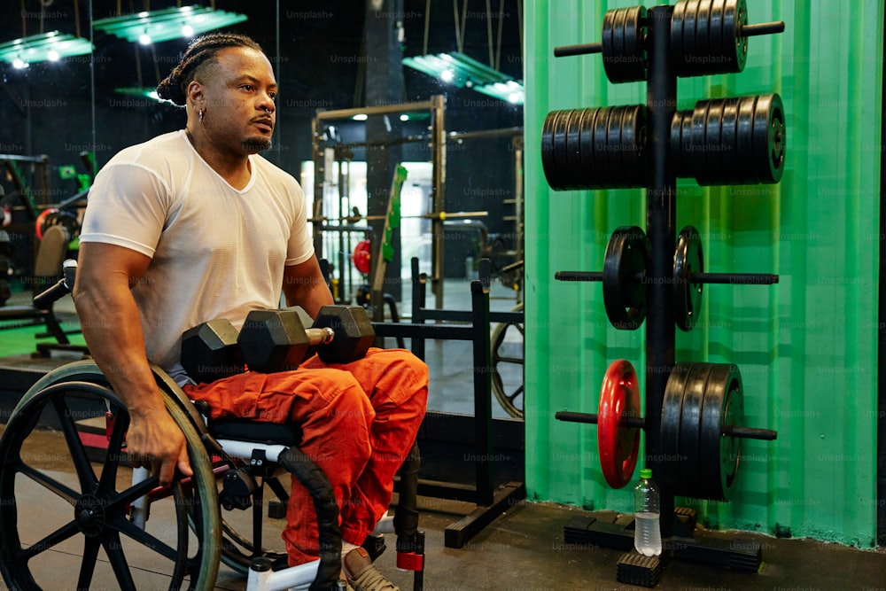 a man sitting in a wheel chair in a gym