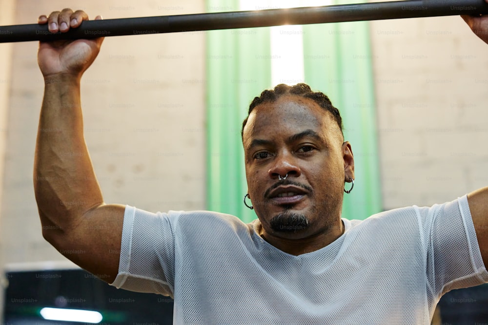 a man holding a bar in a gym