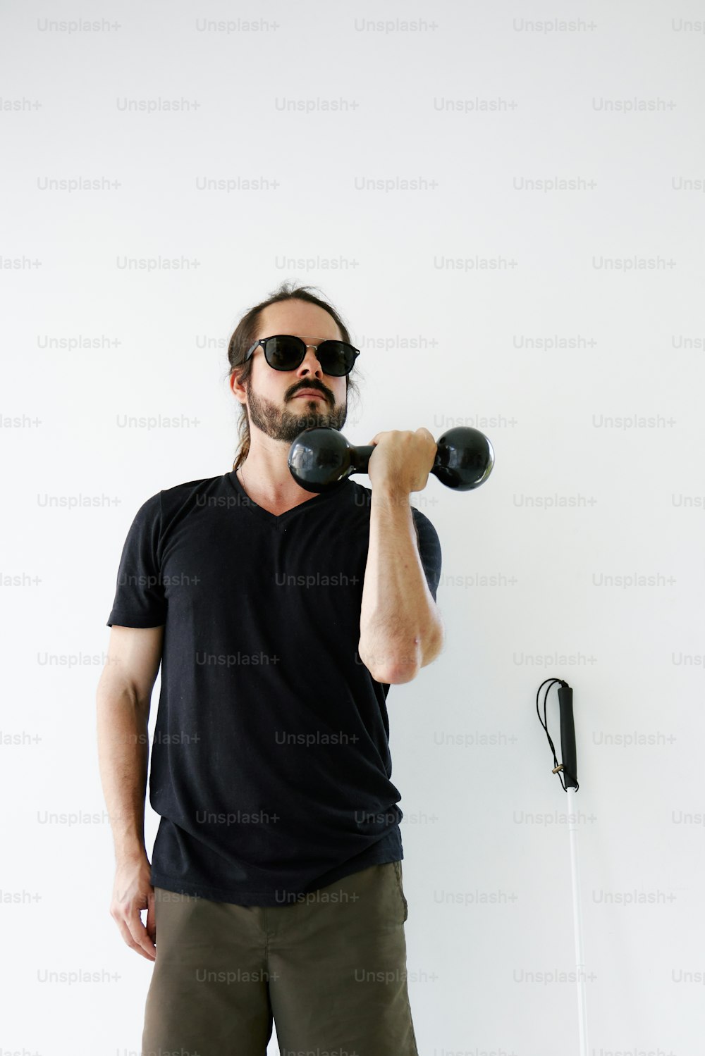 a man holding a pair of dumbbells in his right hand