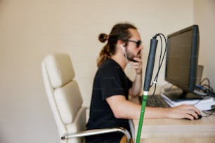 Ein Mann, der an einem Schreibtisch sitzt und einen Computer benutzt