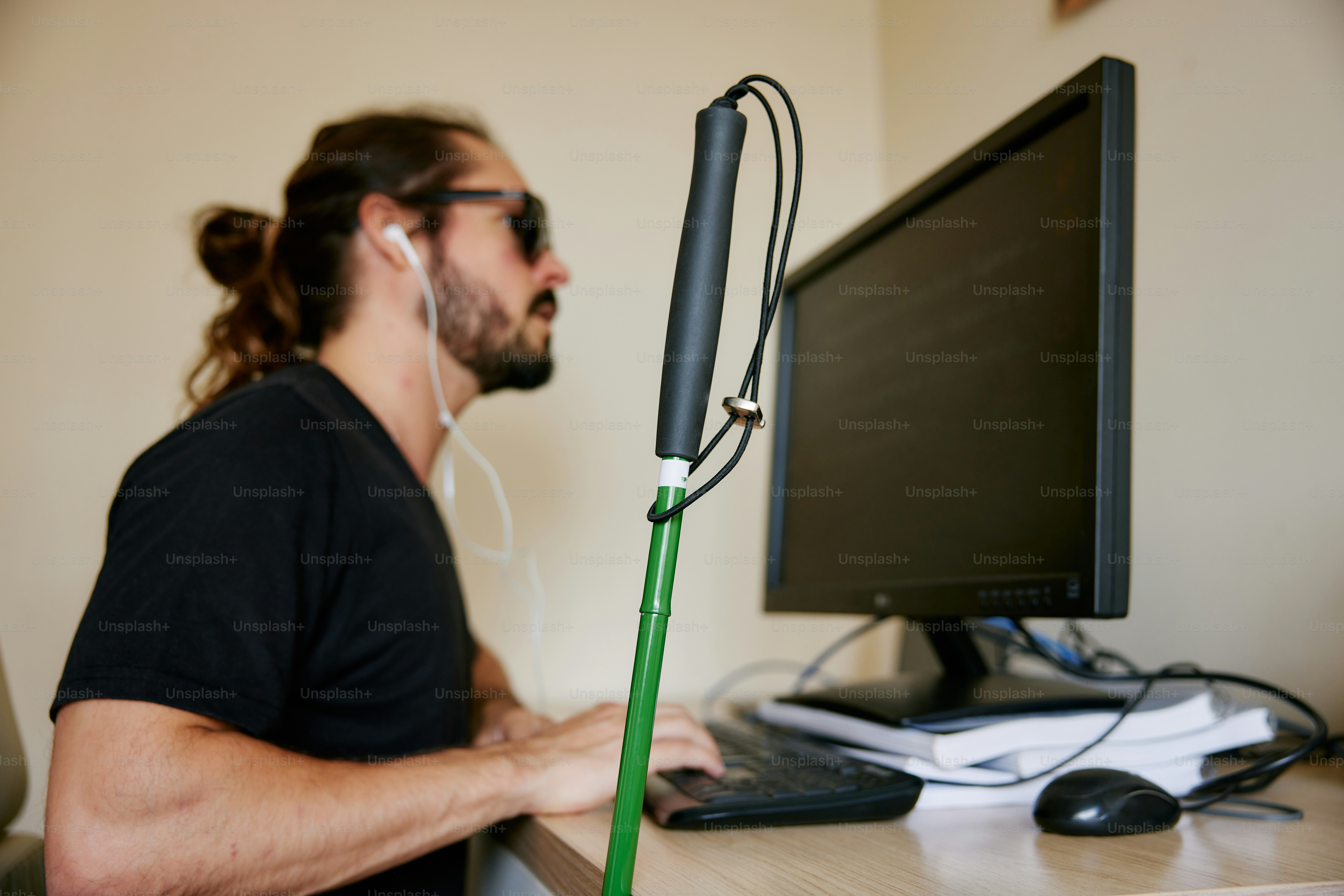 ヘッドフォンをつけたままコンピューターの前に座っている男性