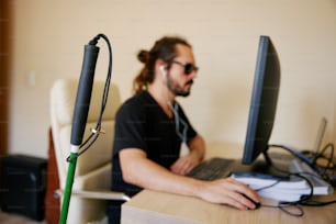 Un hombre sentado frente a una computadora en un escritorio