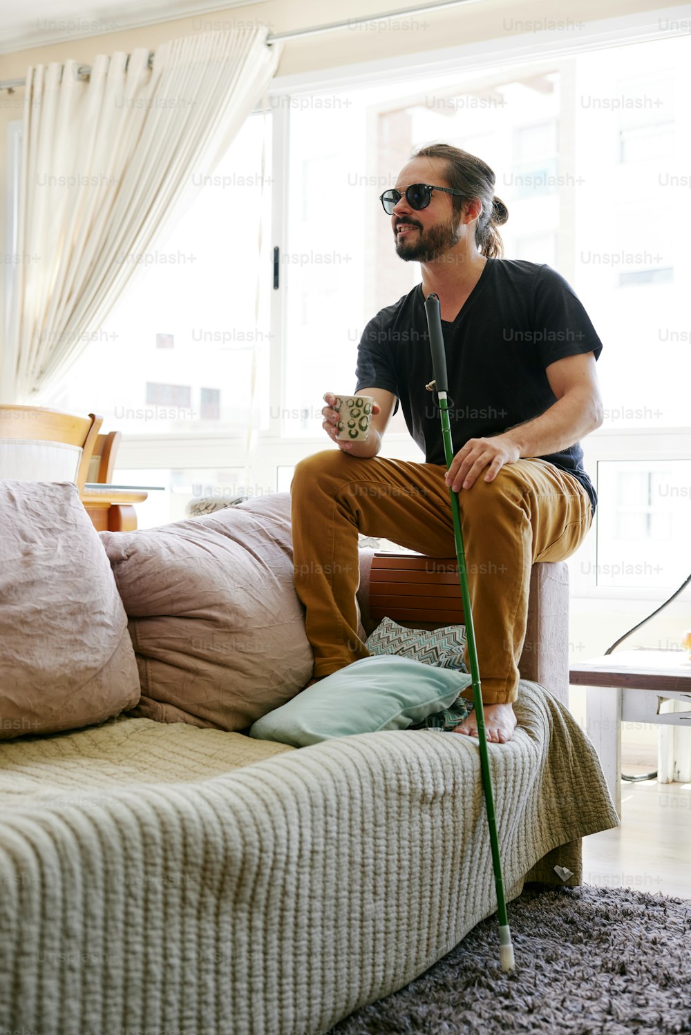 a man sitting on a couch with a cane