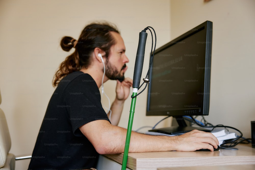 컴퓨터를 사용하여 책상에 앉아 있는 남자