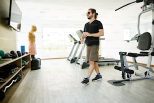 Un hombre parado frente a una máquina de gimnasio