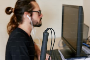 a man wearing headphones and a microphone in front of a computer