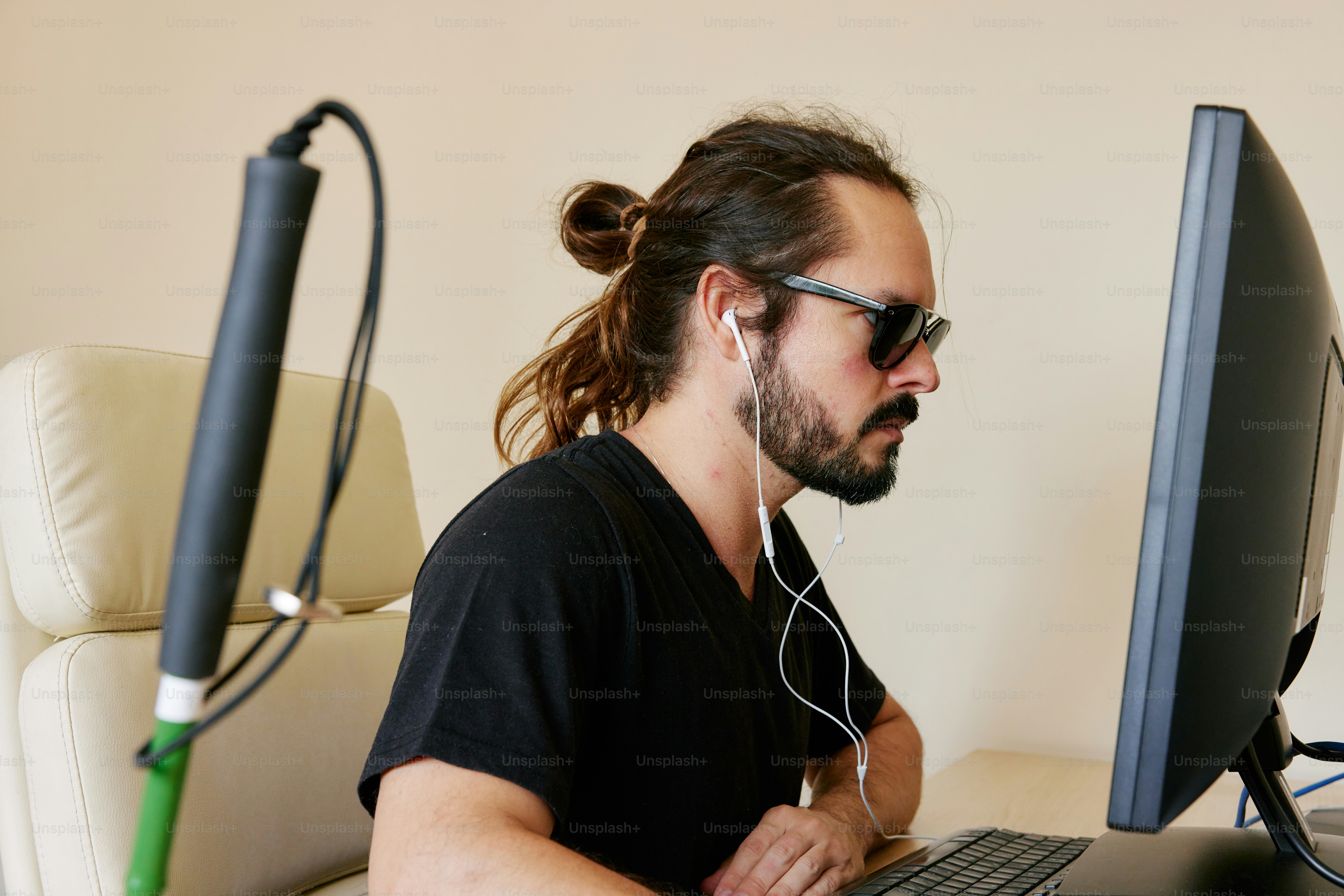 A man sitting in front of a computer with headphones on photo ...