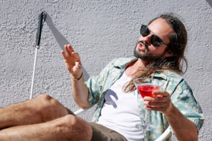 a man sitting in a chair holding a drink