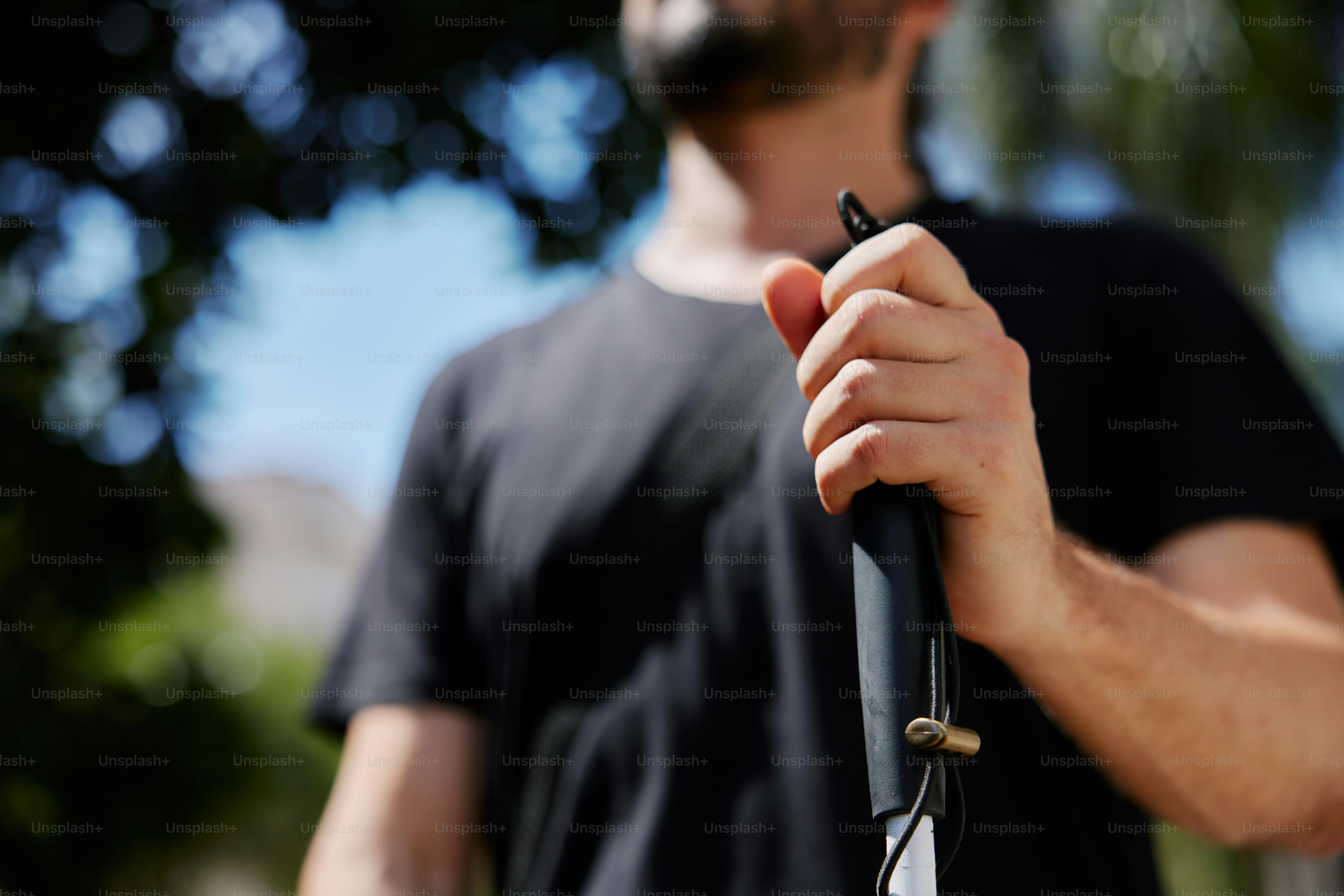 Un hombre sosteniendo un paraguas negro en la mano