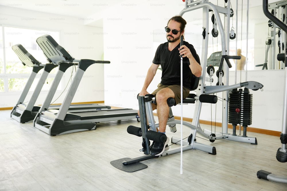 a man sitting on a machine in a gym