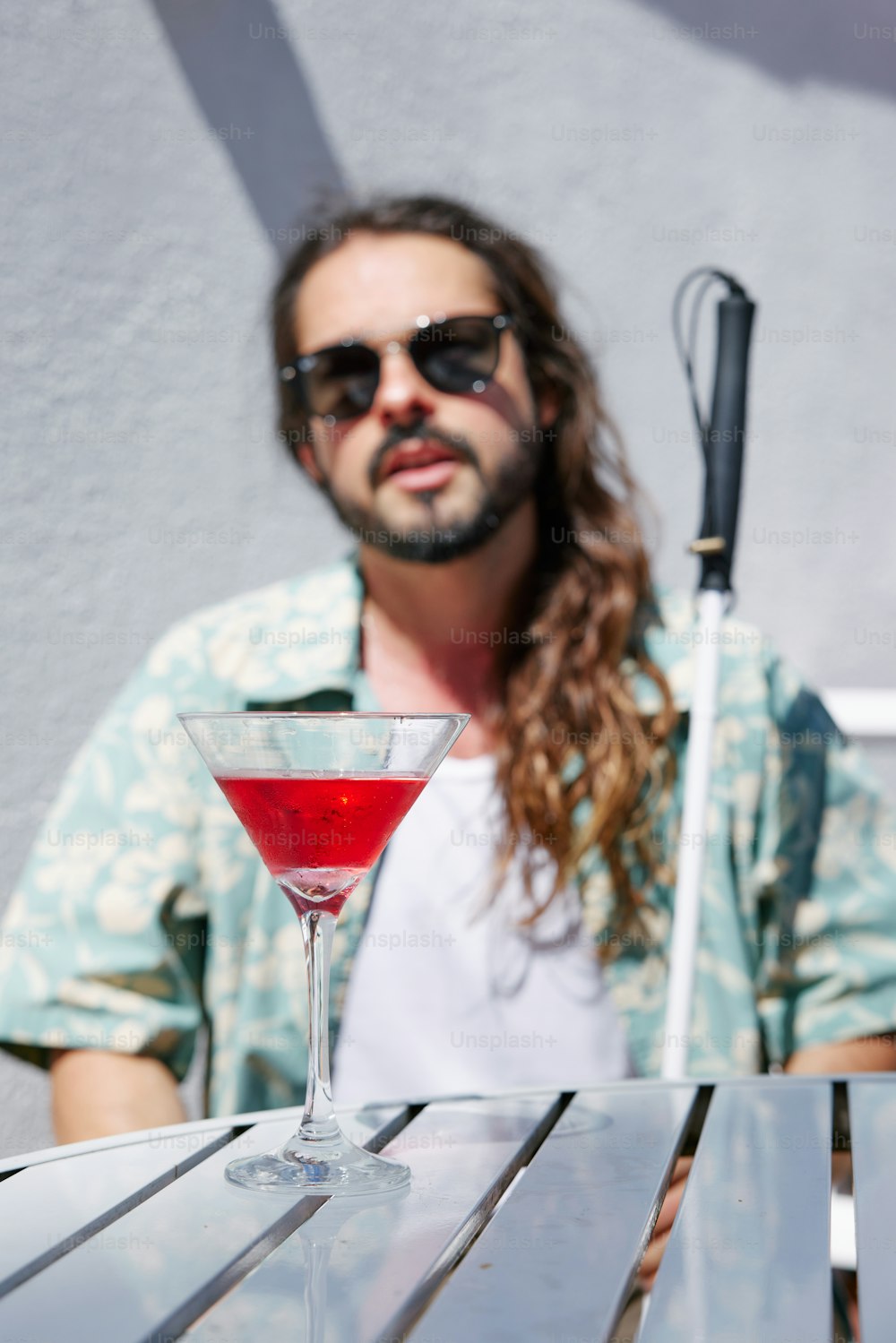 Un hombre sentado en una mesa con una bebida frente a él
