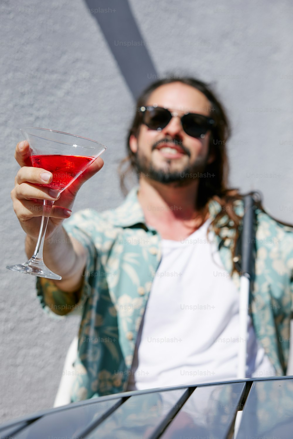 a man holding a wine glass with a red liquid in it