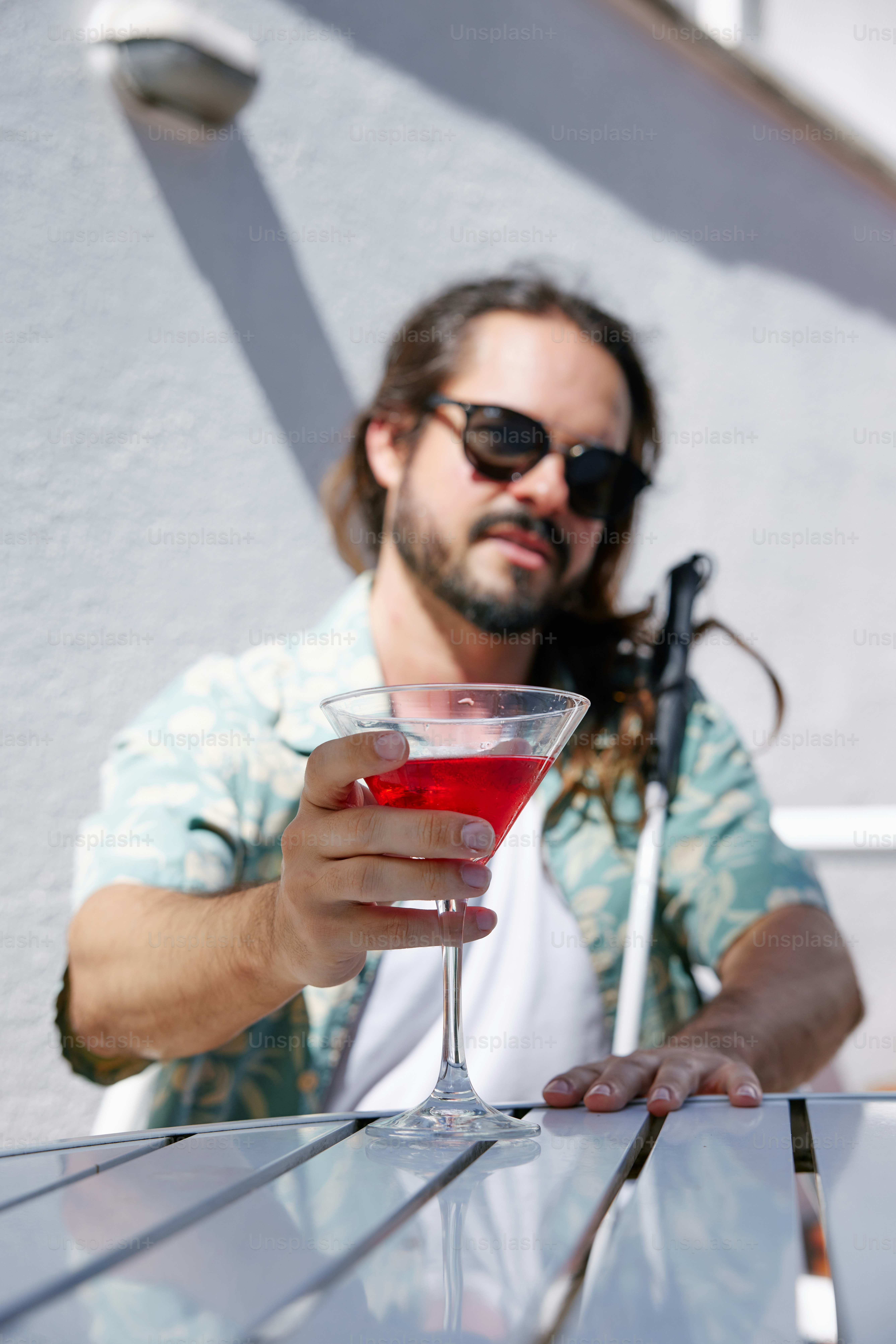 飲み物を手にテーブルに座っている男