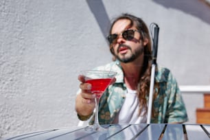 a man sitting at a table with a drink in his hand