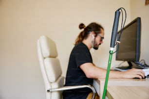 un homme assis à un bureau utilisant un ordinateur