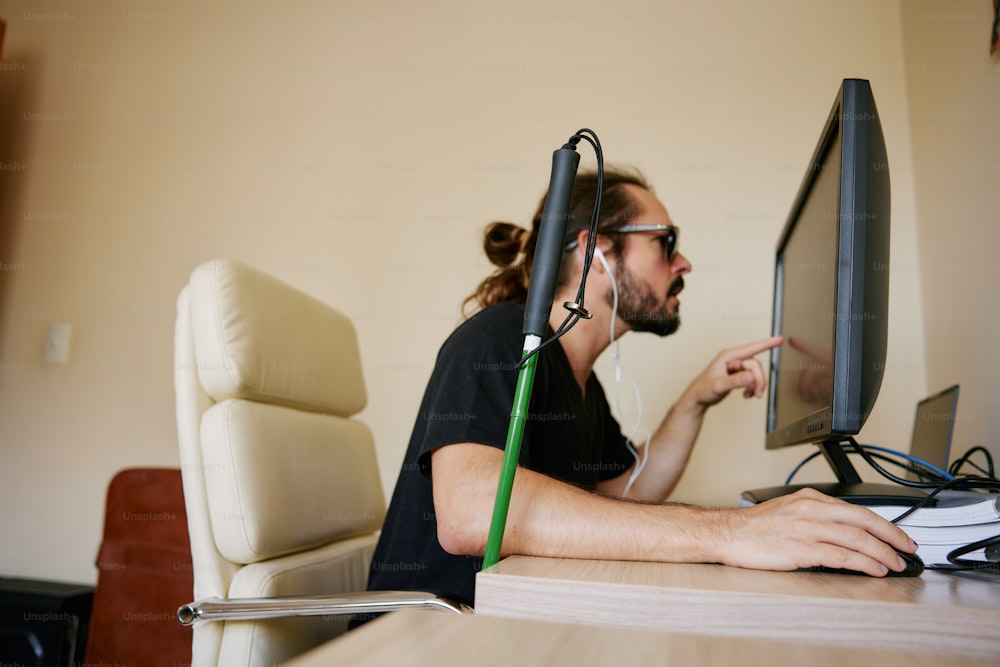 Un hombre sentado frente a un monitor de computadora