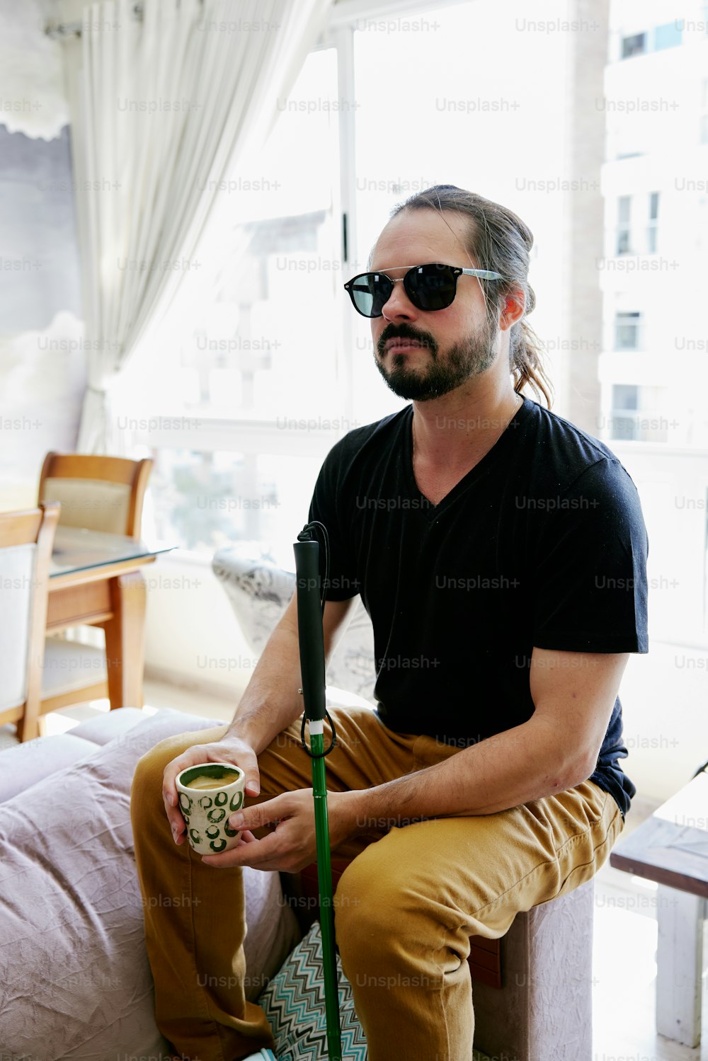 a man sitting on a couch holding a cup of coffee