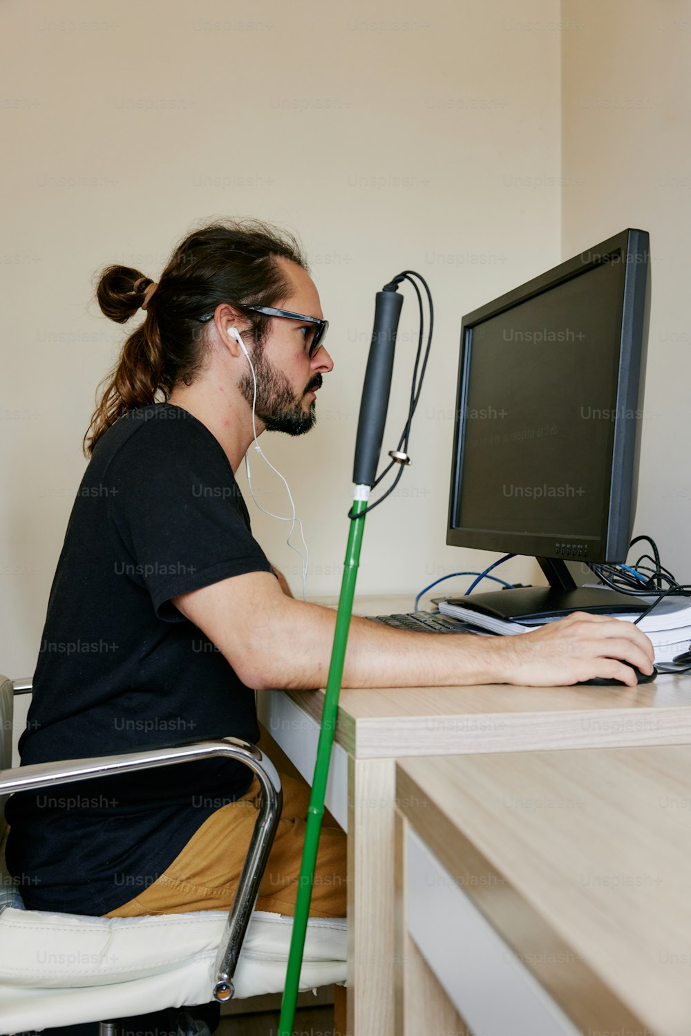 Un hombre sentado en un escritorio usando una computadora