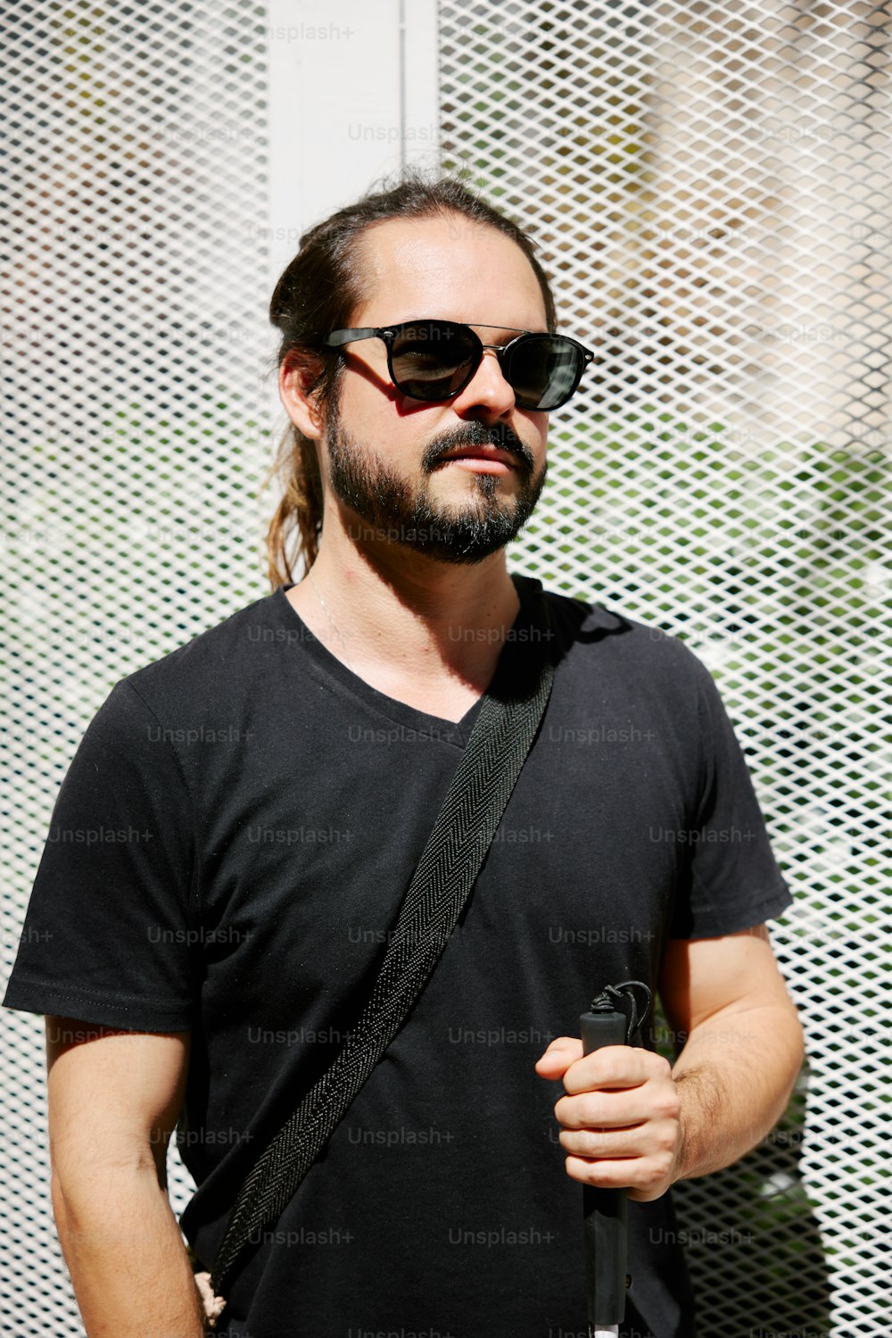 a man with long hair and sunglasses holding a cell phone