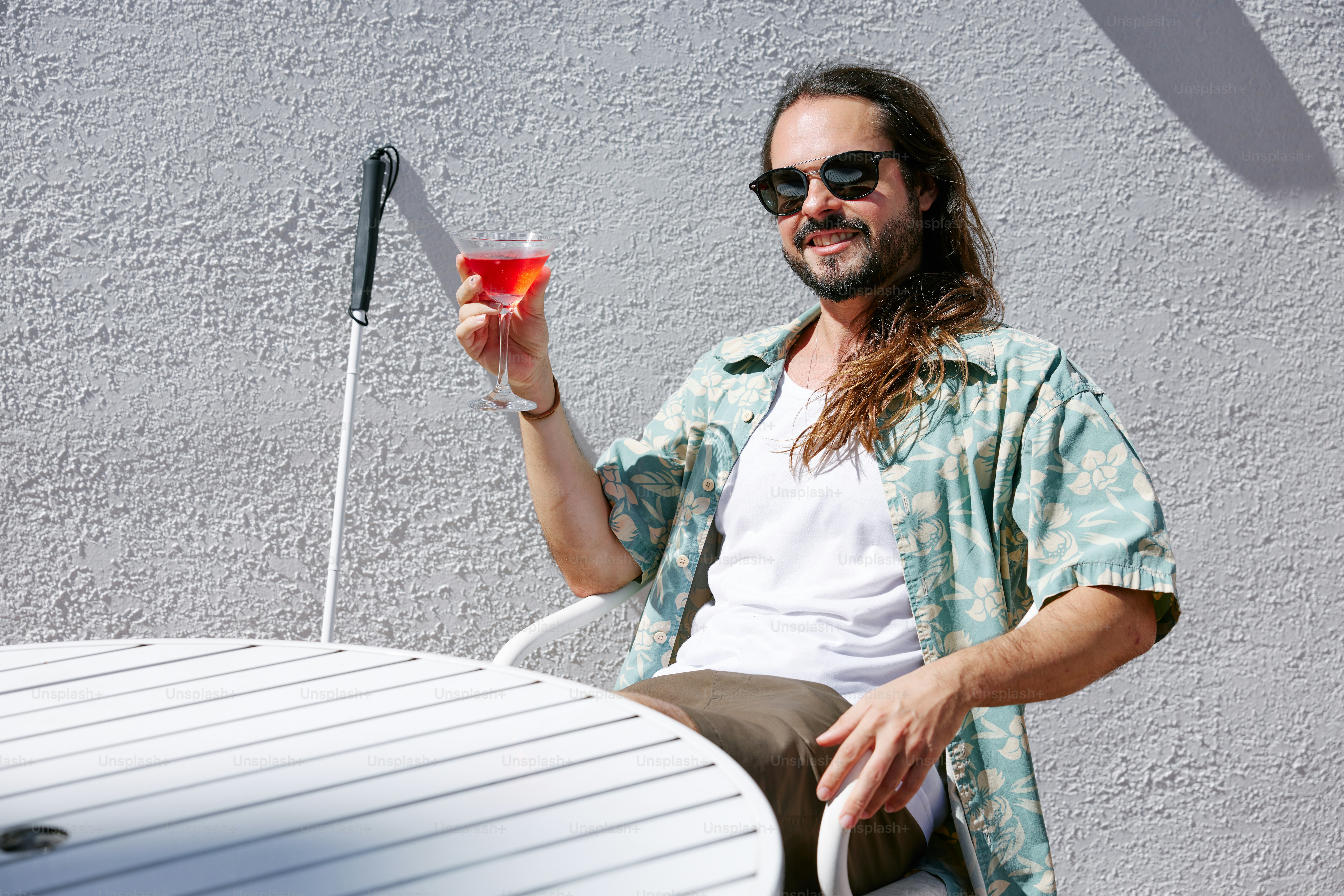テーブルに座って飲み物を持っている男性