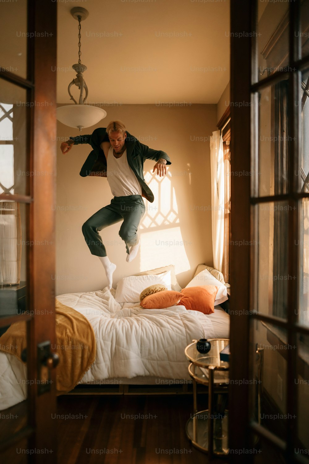 Ein Mann springt auf einem Bett in die Luft