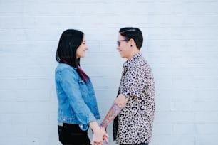 a man and woman standing next to each other and looking at each other