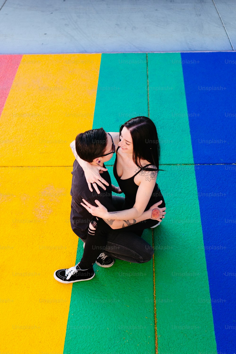 a man and woman kissing on a yellow and blue mat