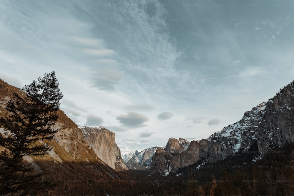 Una vista de una cadena montañosa con árboles y montañas al fondo