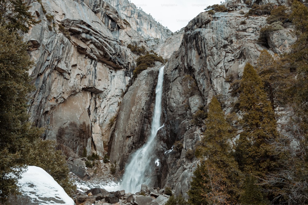 a waterfall in the middle of a rocky mountain