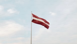 a red and white flag on a flagpole