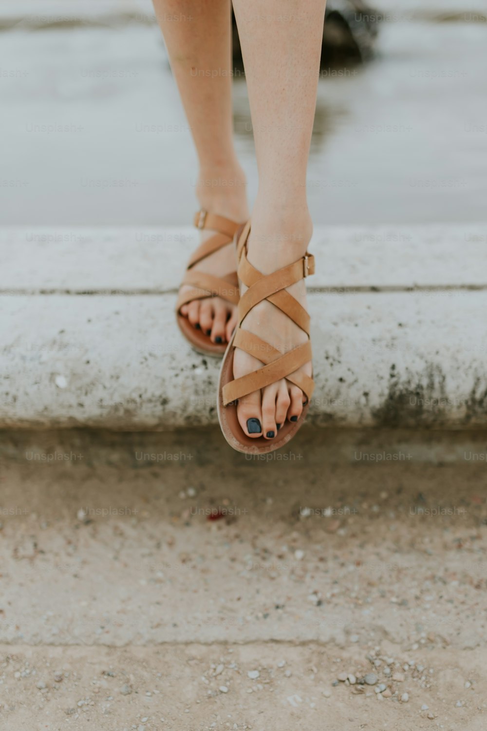 os pés de uma mulher vestindo sandálias e um vestido