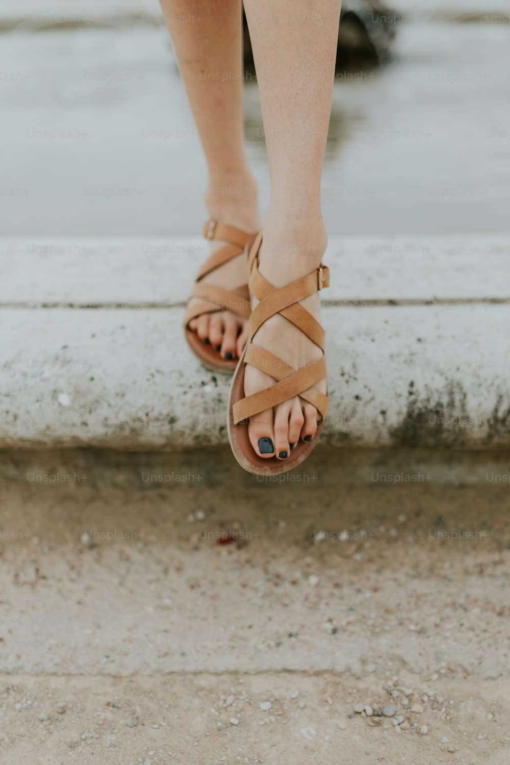 a woman's feet wearing sandals and a dress