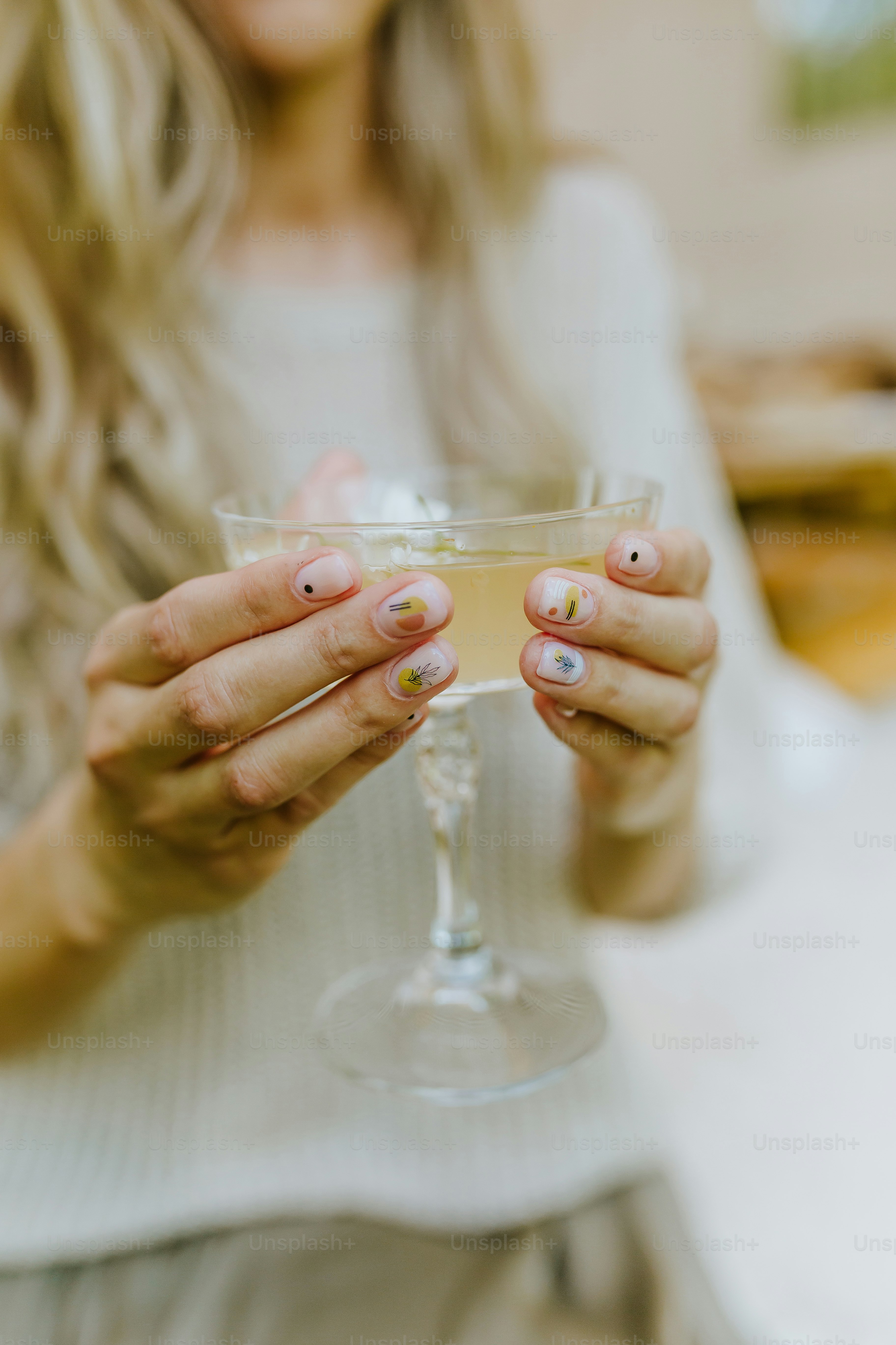 una donna che tiene un bicchiere di vino tra le mani