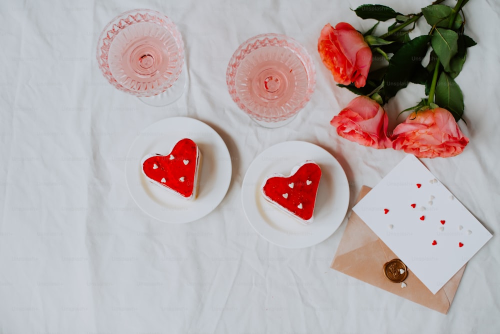 a group of red and white plates with roses on a white surface