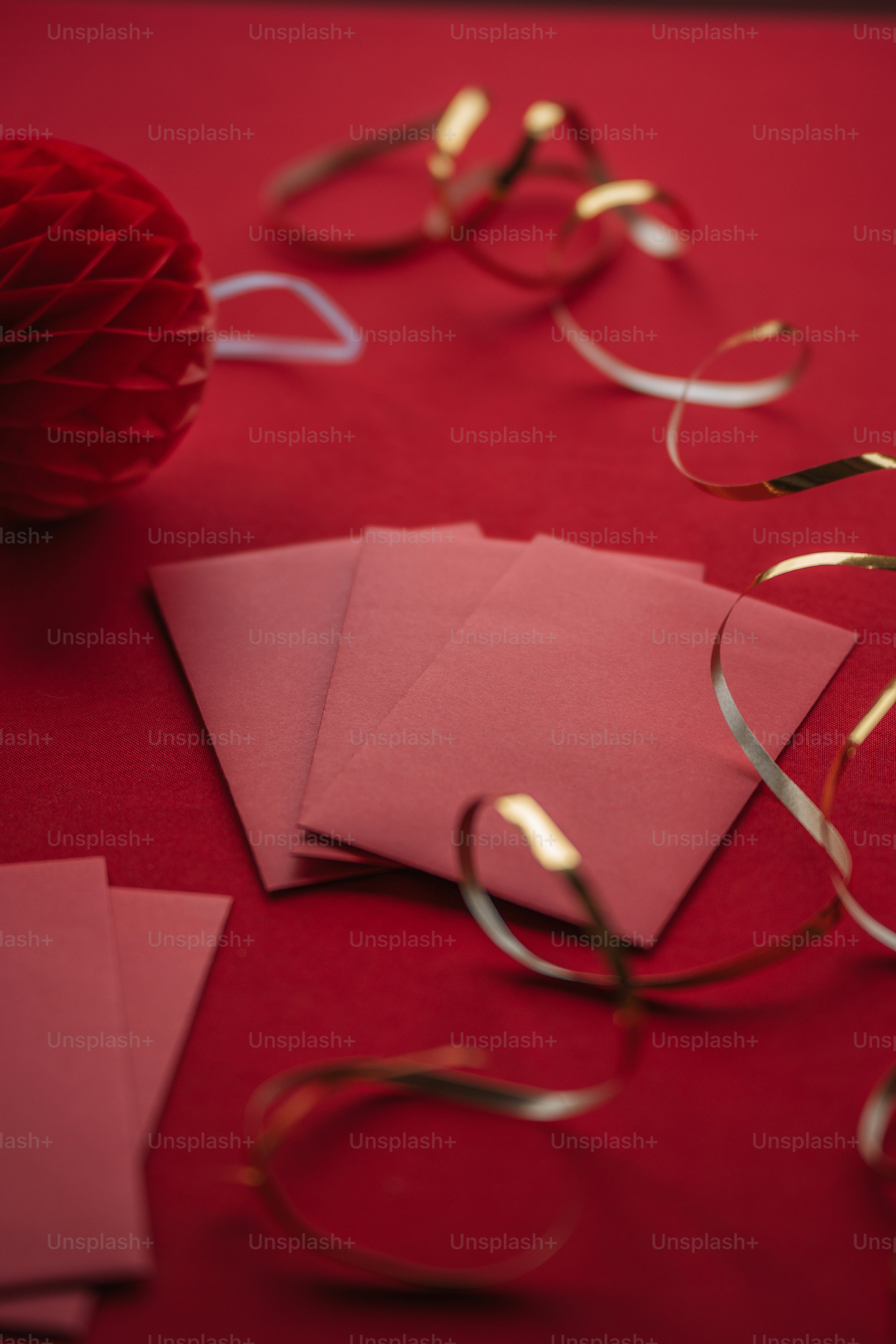 a red table topped with pink envelopes and a red ball
