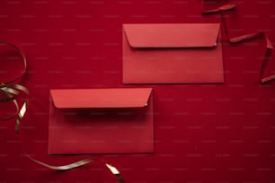 une paire d’enveloppes rouges sur fond rouge