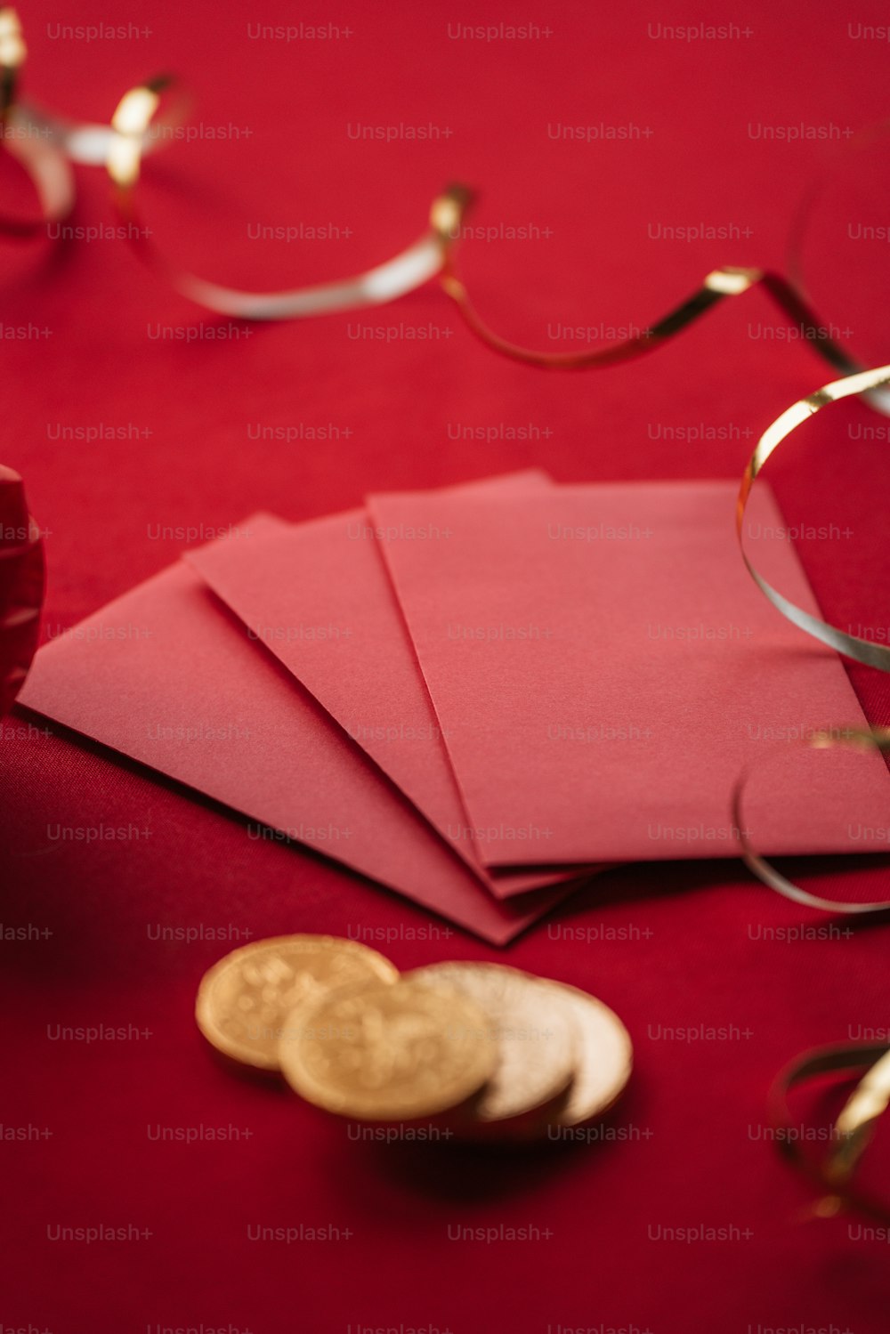 a red table topped with lots of paper and gold coins