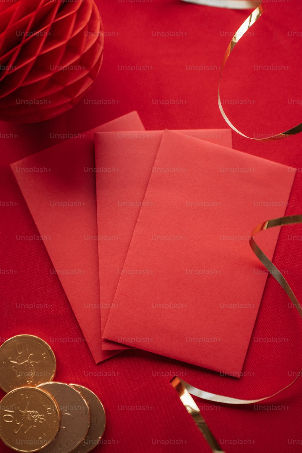 a red table topped with red envelopes and gold coins