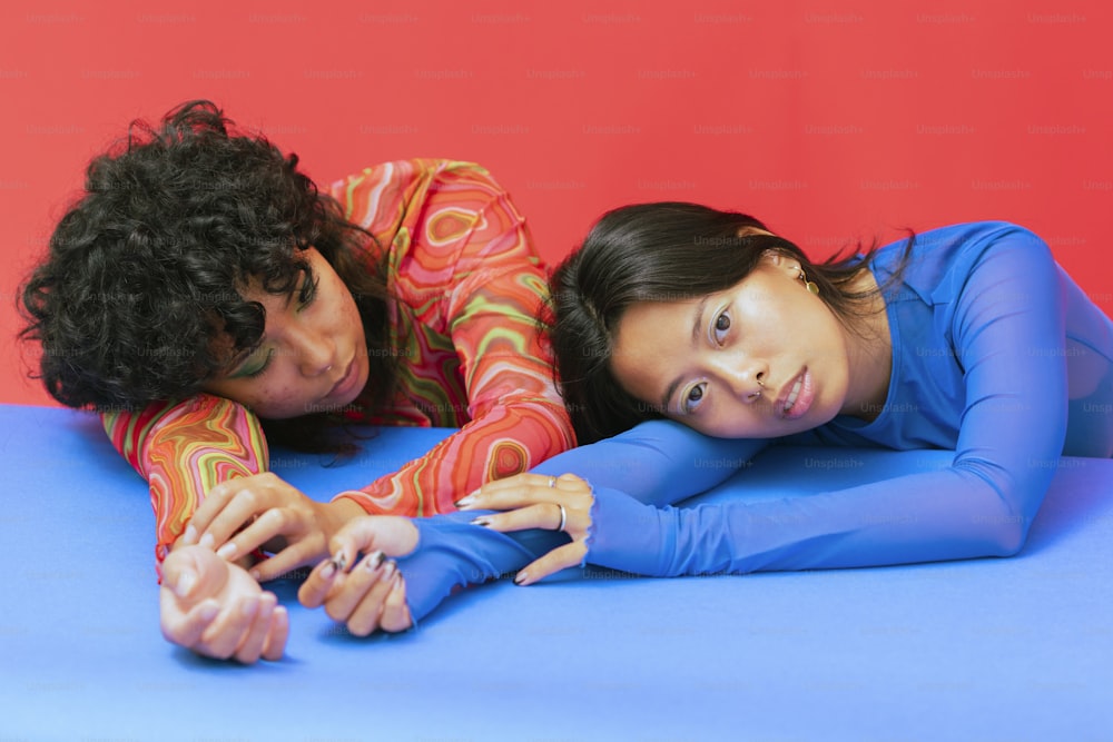a person and a boy lying on a blue surface