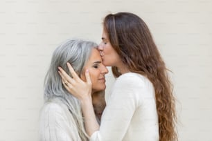 a person kissing another woman