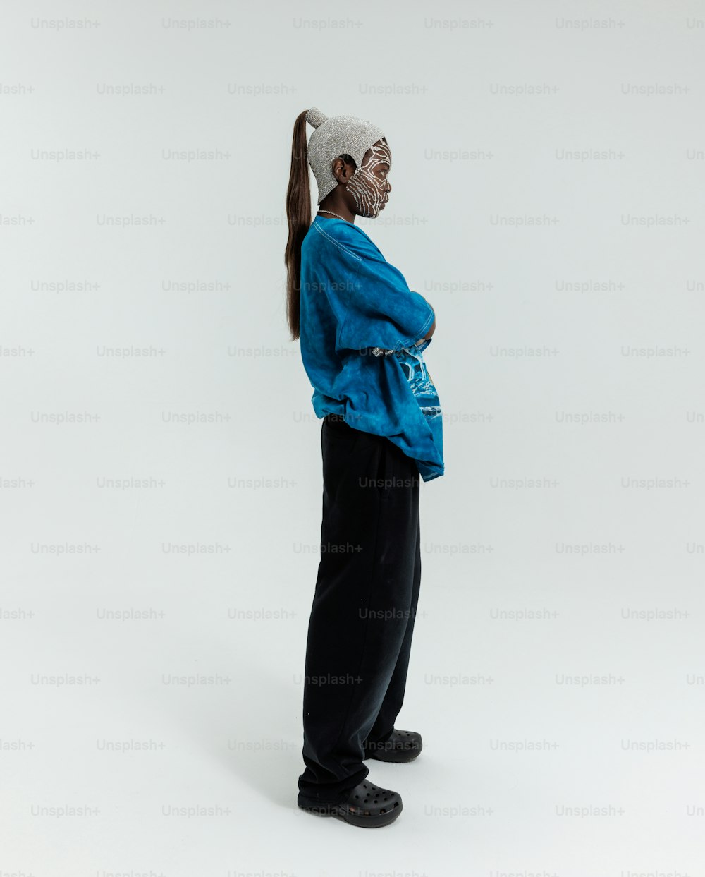 a man with a ponytail standing in front of a white background