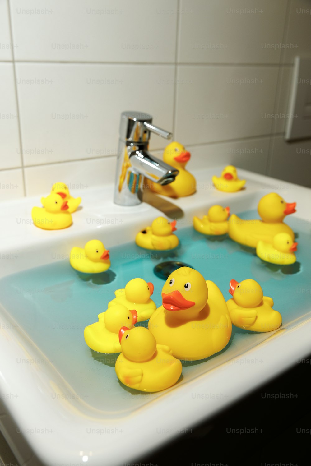 a group of yellow rubber ducks in a sink