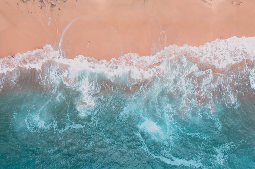 Una vista aérea de una playa con olas y arena
