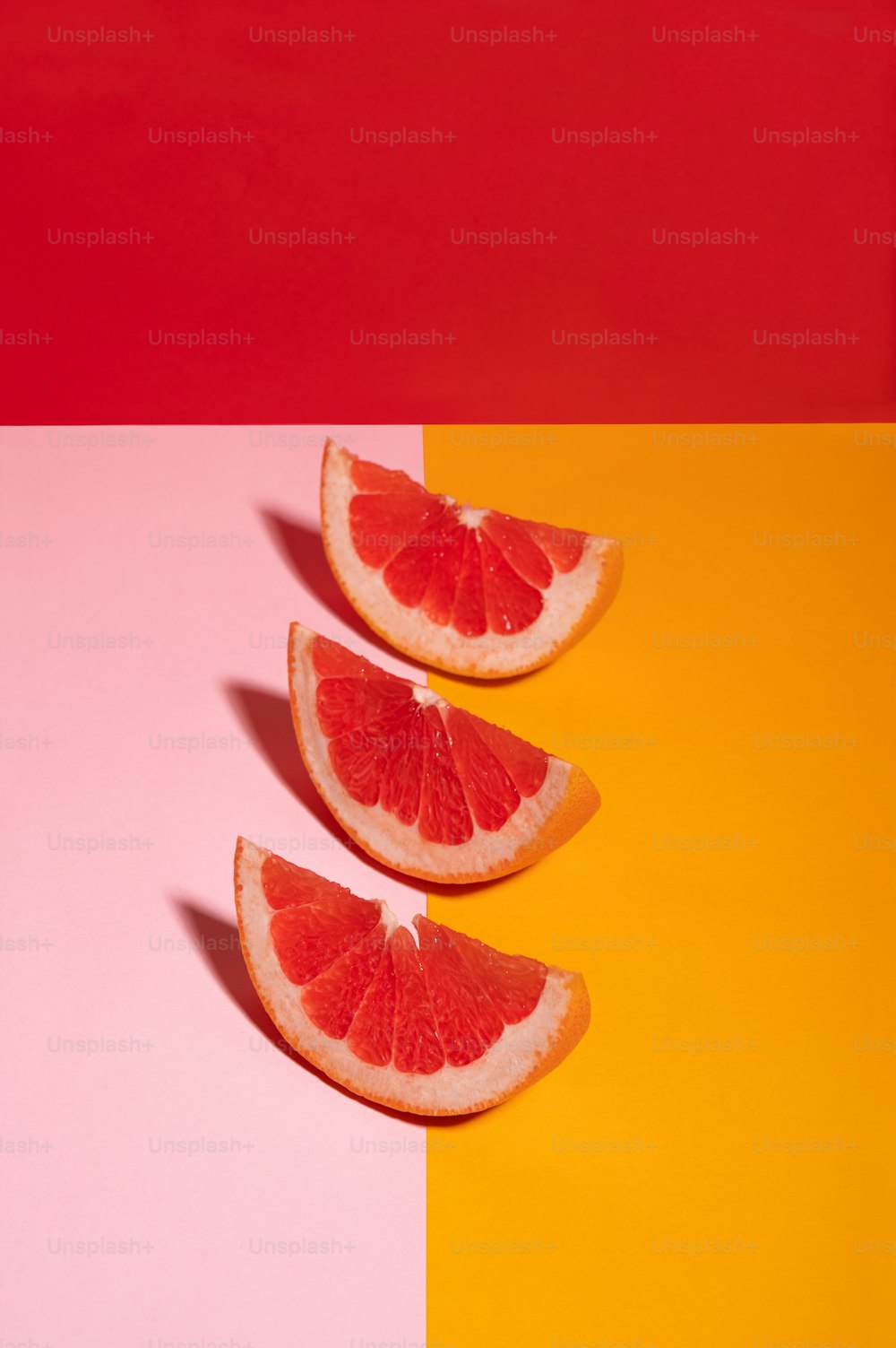 three grapefruits cut in half on a multi - colored background