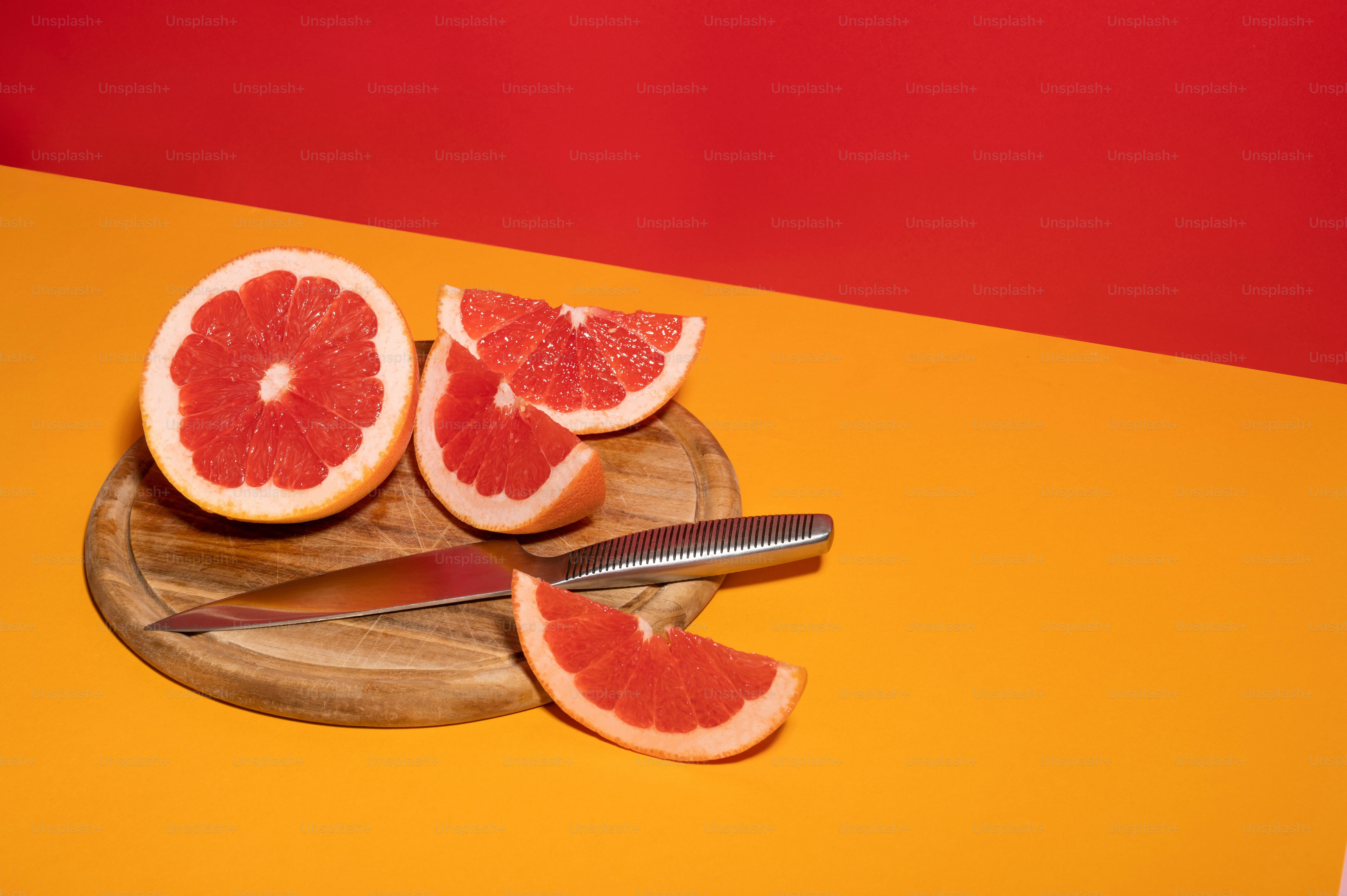 eine Grapefruit in zwei Hälften geschnitten auf einem Schneidebrett
