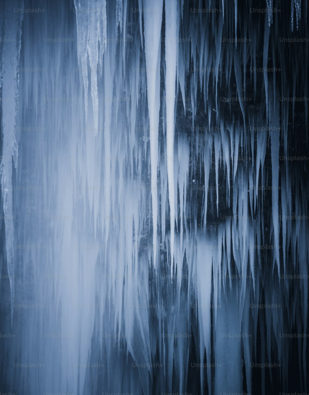 a group of icicles hanging from the ceiling of a cave