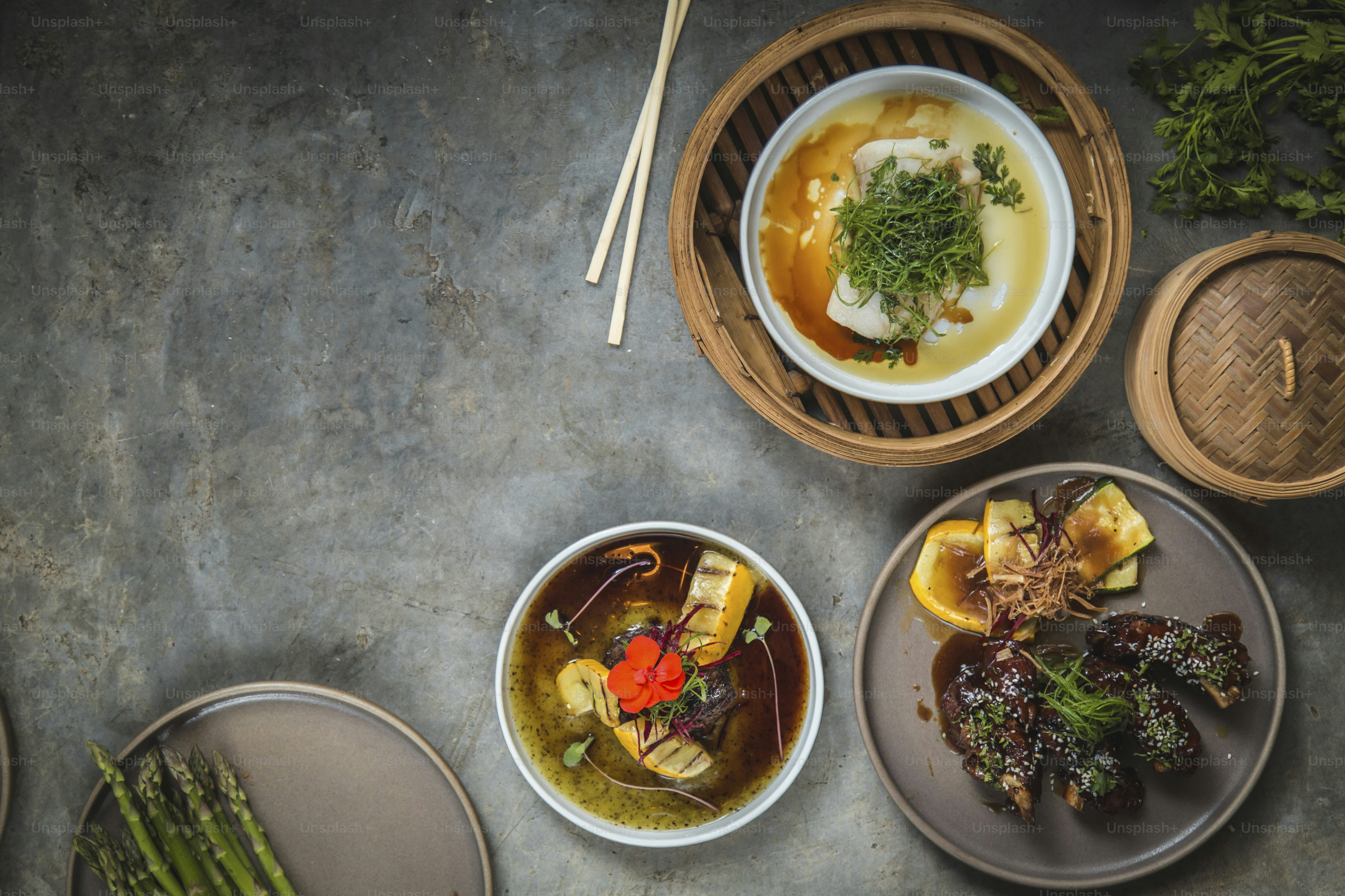a table topped with plates of food and bowls of soup